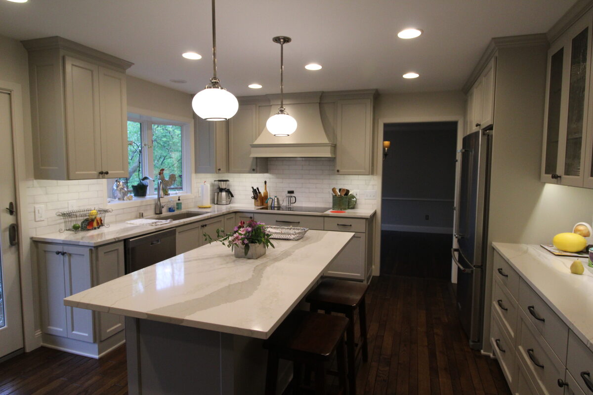 Sage-gray shaker kitchen with marble waterfall island