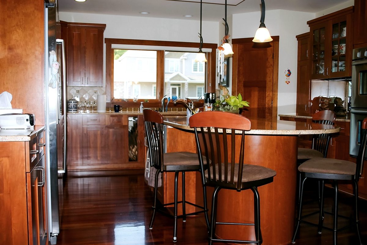 Cherry kitchen with raised island seating, pendant lighting, and dark wood floors