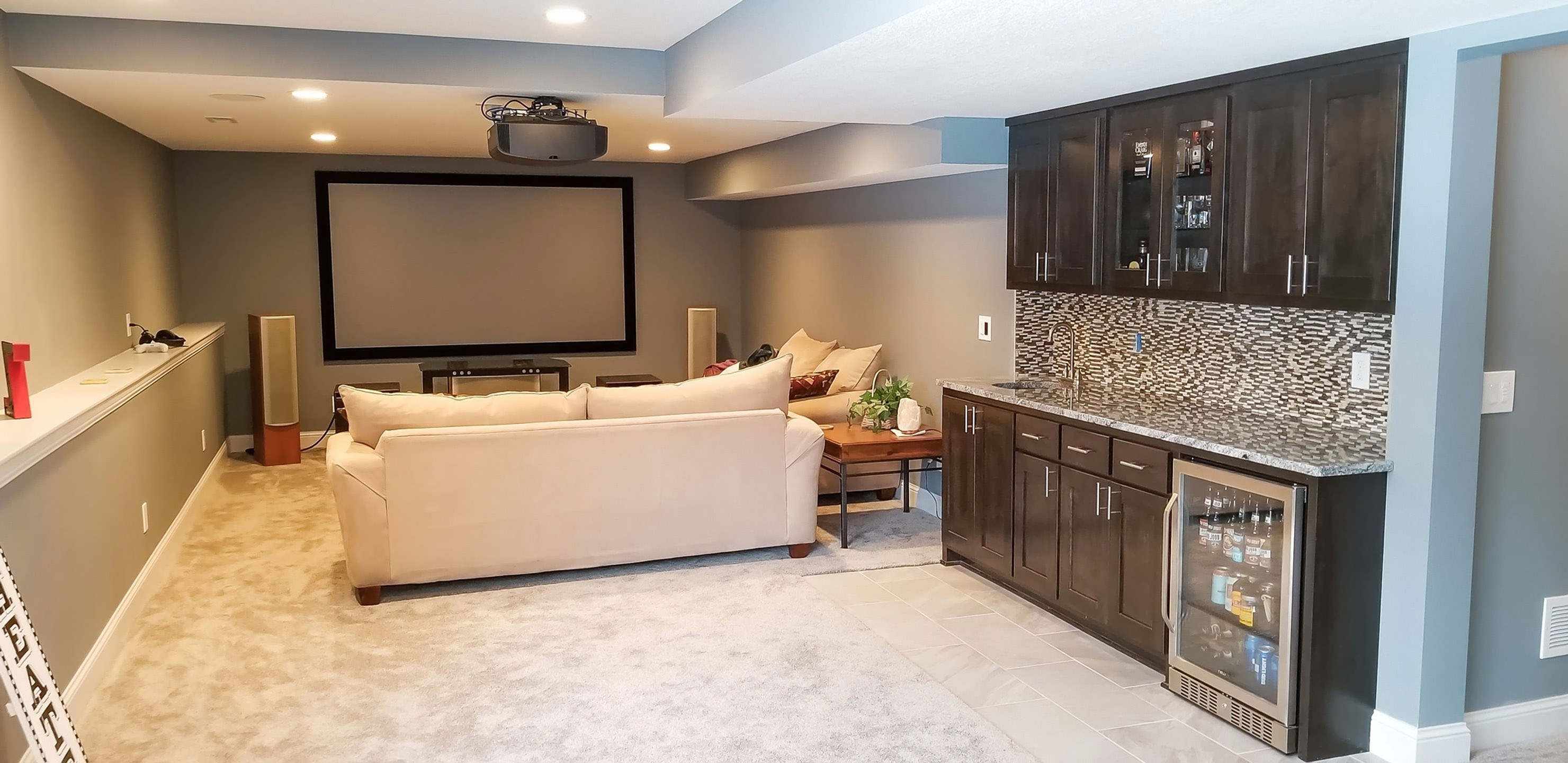 Finished basement family room with theater and wet bar by Kuechle Construction Co.