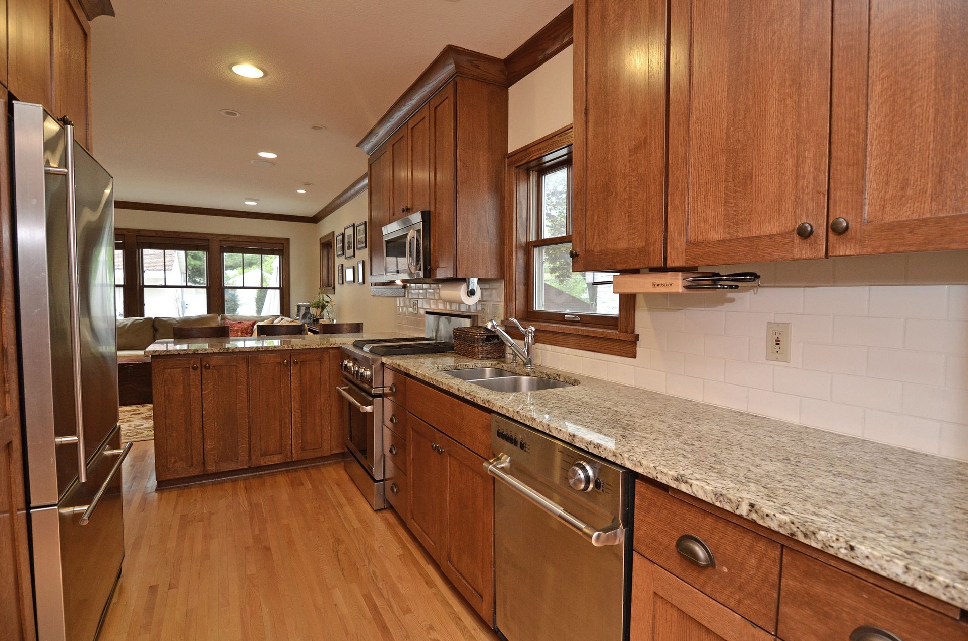 Galley kitchen with oak cabinetry and stone counters.