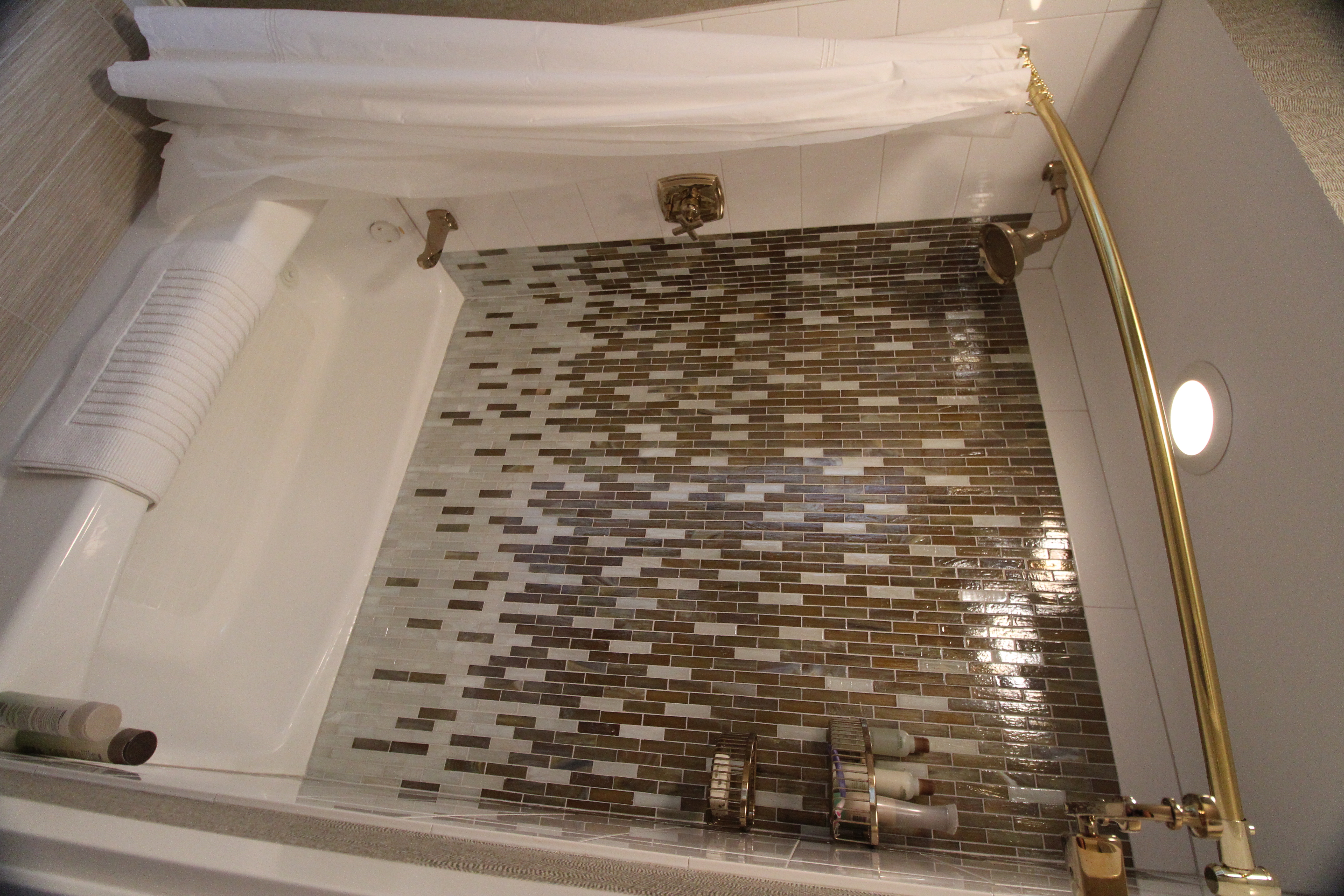 Freestanding soaking tub positioned beneath a window to maximize natural light