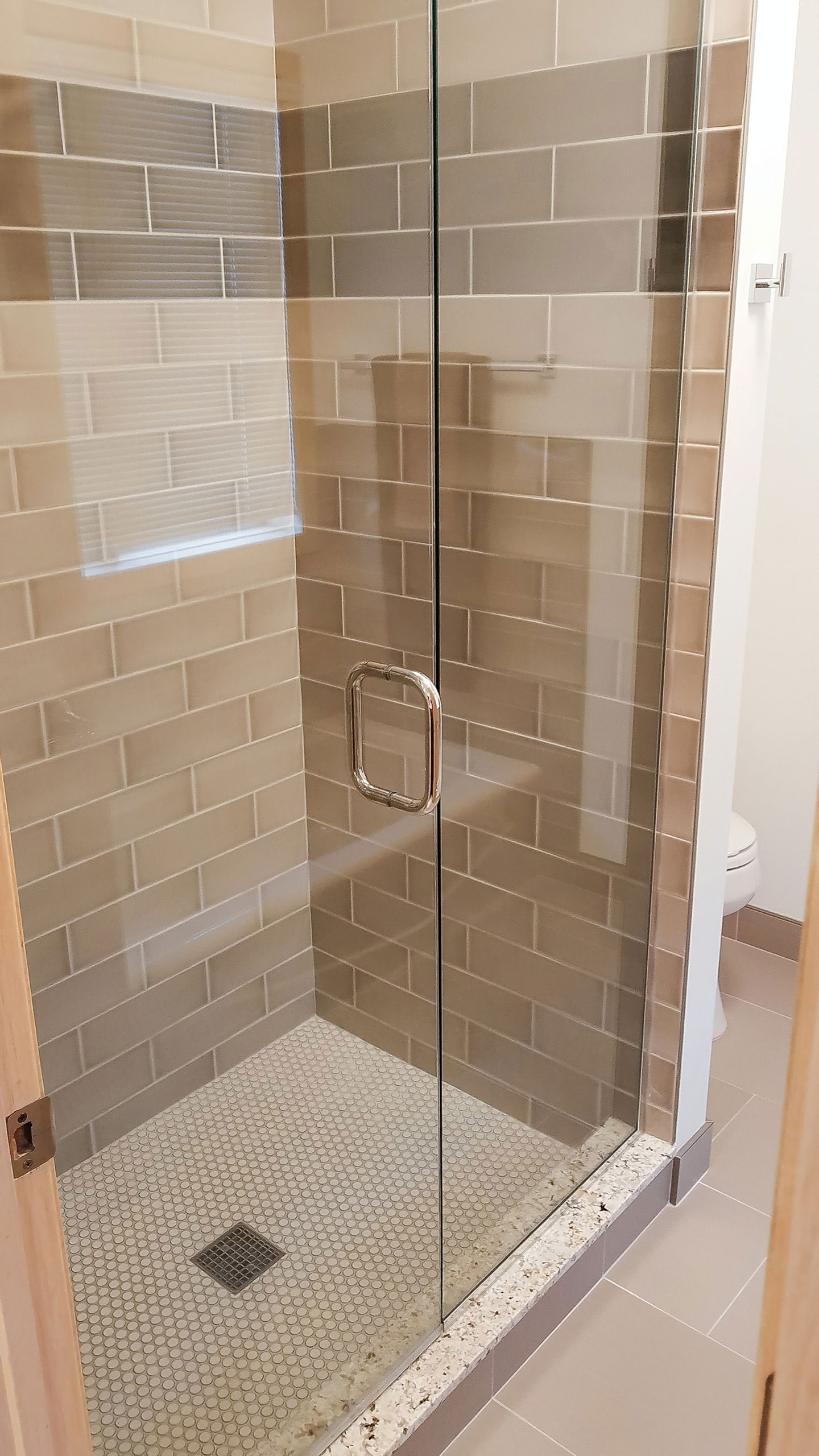 Frameless shower enclosure with tile base and precise glass installation
