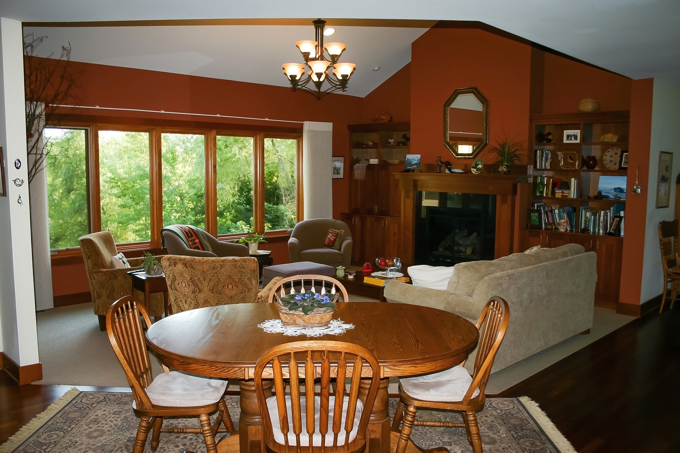 Lower level hallway with warm wood trim, modern wall sconces, and a comfortable lounge area ahead.